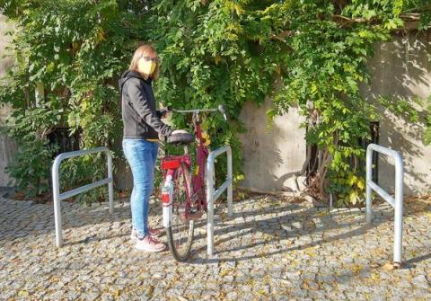 Frau mit Fahrrad an Anlehnbügel