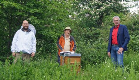 Drei Männer vor Bienenstock