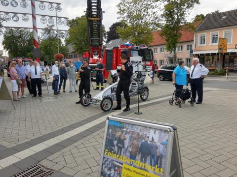 Szene Stadtfest, im Hintergrund Stand mit Löschfahrzeug und Feuerwehrleuten