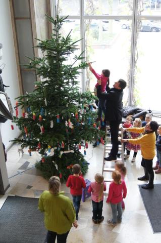 Kinder des Familienzentrums Leibnizstraße schmücken den Weihnachtsbaum im Neukirchen-Vluyner Rathaus